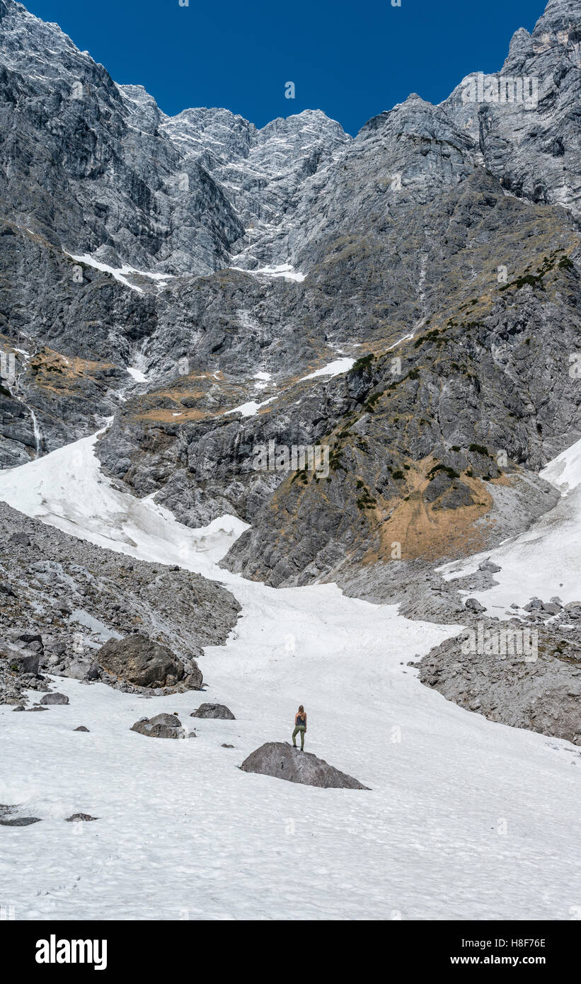 Debout sur le roc, randonneur Alpes allemandes de neige profonde, Watzmann Face Est, Berchtesgaden, Bavière, Allemagne Banque D'Images