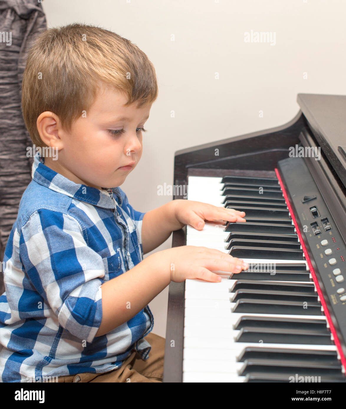 Peu heureux garçon joue du piano à l'accueil Photo Stock - Alamy