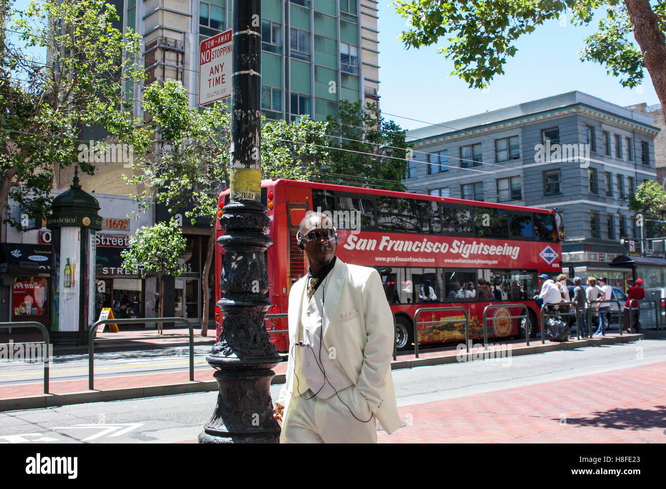 San Francisco, USA - 12 juin 2010. Homme noir représentant en costume blanc marche sur la rue et fumer un cigare. Banque D'Images