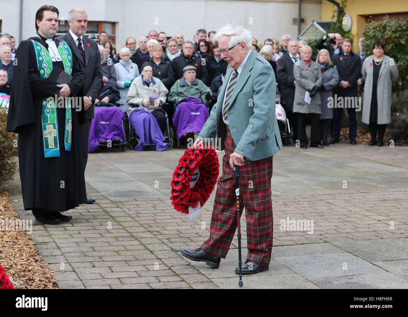 Ancien combattant Peter Knowles (centre) du Royal Army Service Corps dépose une couronne au nom de l'Anciens Combattants Erskine lors d'une cérémonie du Souvenir le jour de l'Armistice à Erskine Accueil à Bishopton, en Écosse. Banque D'Images