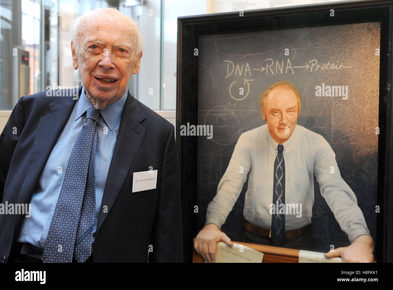 Le Dr James Watson, le biologiste moléculaire américain, zoologiste et généticien, connu comme l'un des co-découvreurs de la structure de l'ADN en 1953 par Francis Crick est à côté d'un portrait de son ancien collègue lors de l'ouverture officielle de la Francis Crick Institute dans le centre de Londres. Banque D'Images