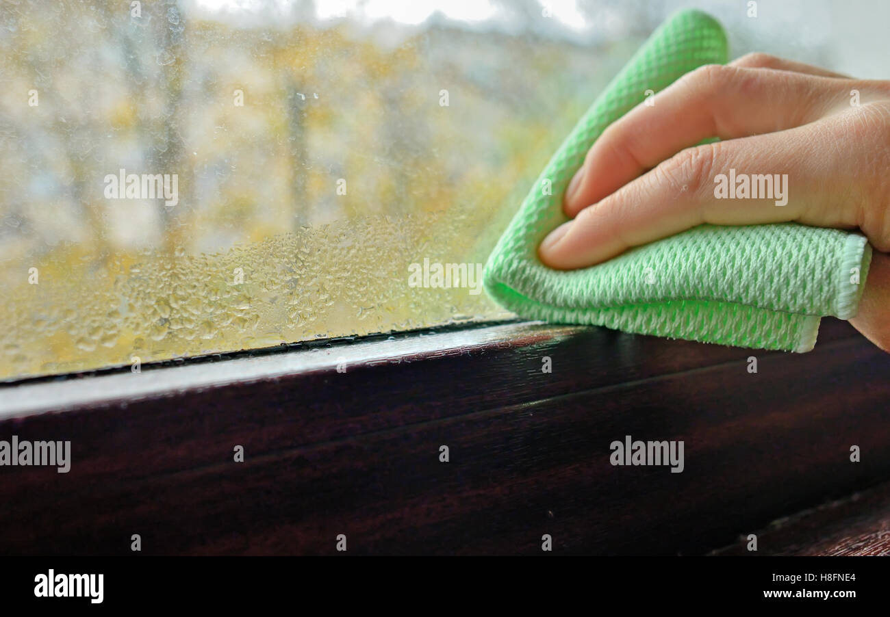 Woman cleaning la condensation de l'eau sur la fenêtre Banque D'Images