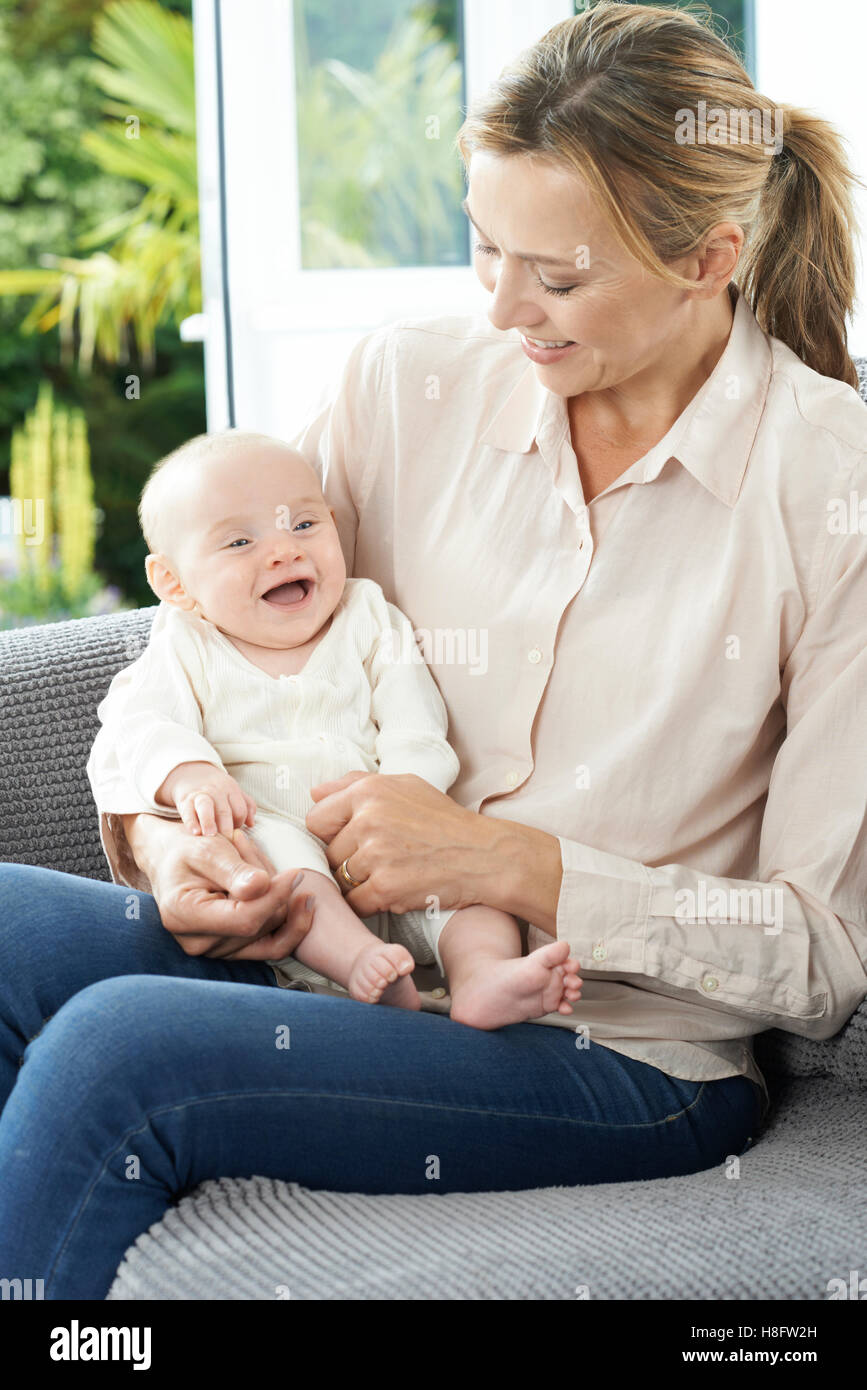 Grand-mère assise sur un canapé avec bébé fille Banque D'Images