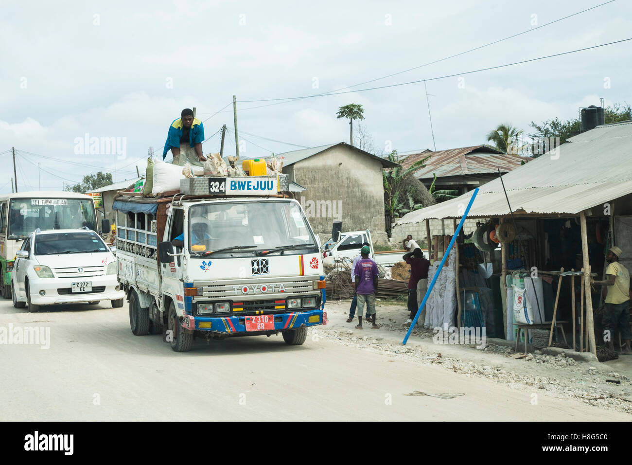 Les sacs sont chargés sur le toit d'un dala-dala à destination de la glacerie sur l'île de Zanzibar Banque D'Images