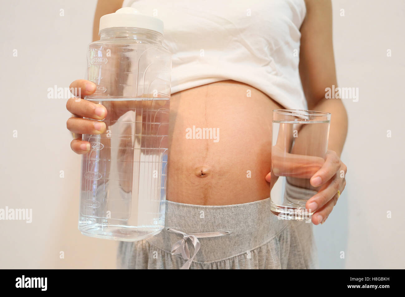 Les femmes enceintes à retenir l'eau verre de verre en main pour concept l'amour pour la santé. Banque D'Images