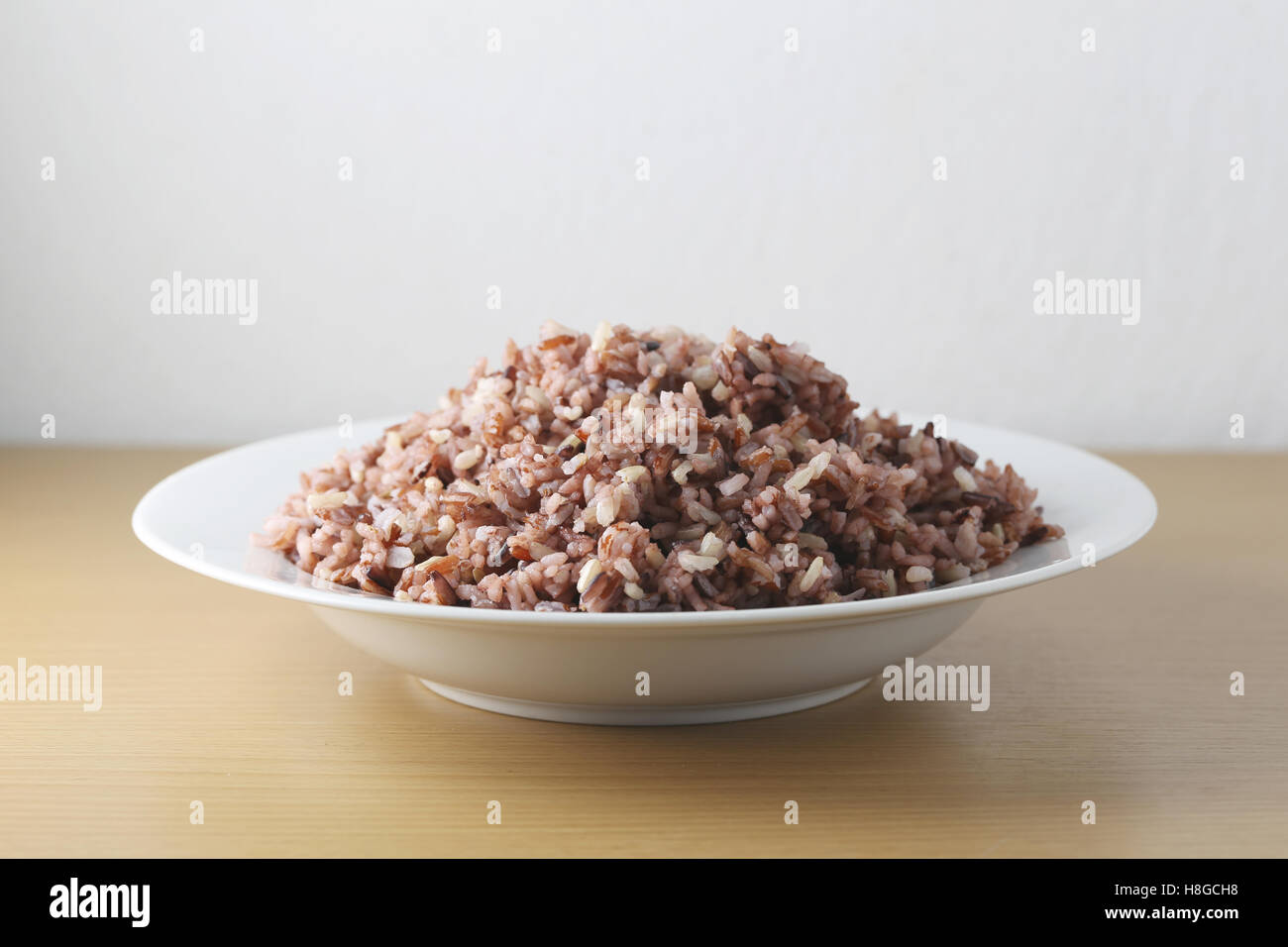 Riz brun cuit thai berry ou brown riz au jasmin dans un plat blanc,concept de santé et de l'hygiène des repas de nourriture pour perdre du poids. Banque D'Images