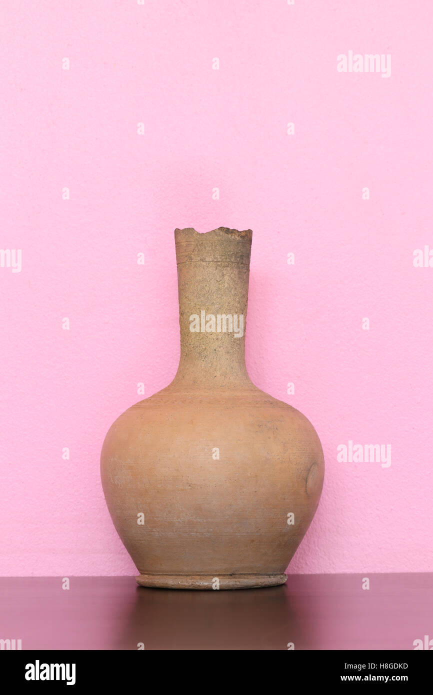 Vase Céramique brun sur la table en bois de rose et le mur. Banque D'Images