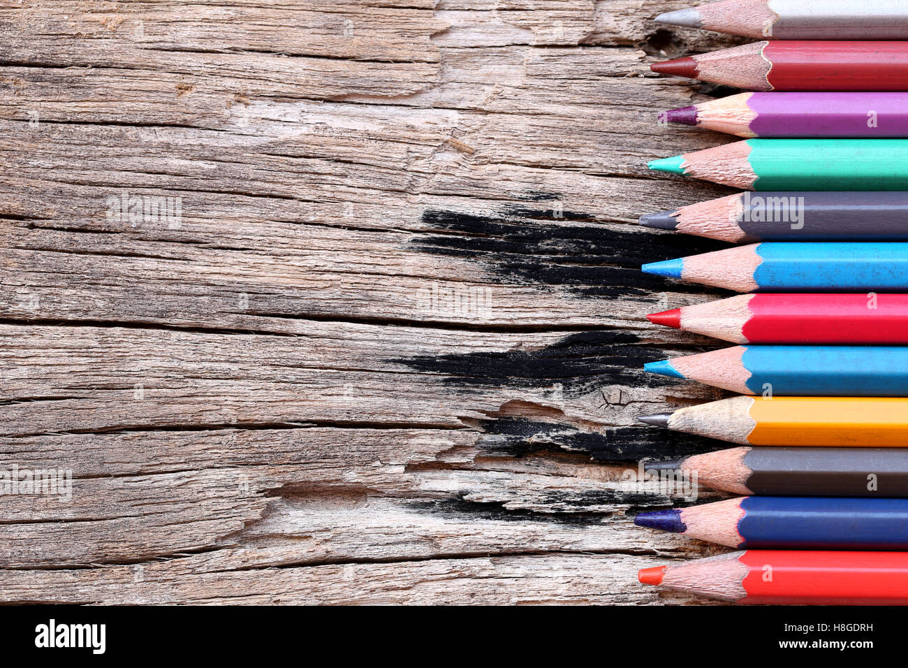 Crayons de couleur ou des crayons sur le vieux plancher en bois concepts sur l'éducation. Banque D'Images