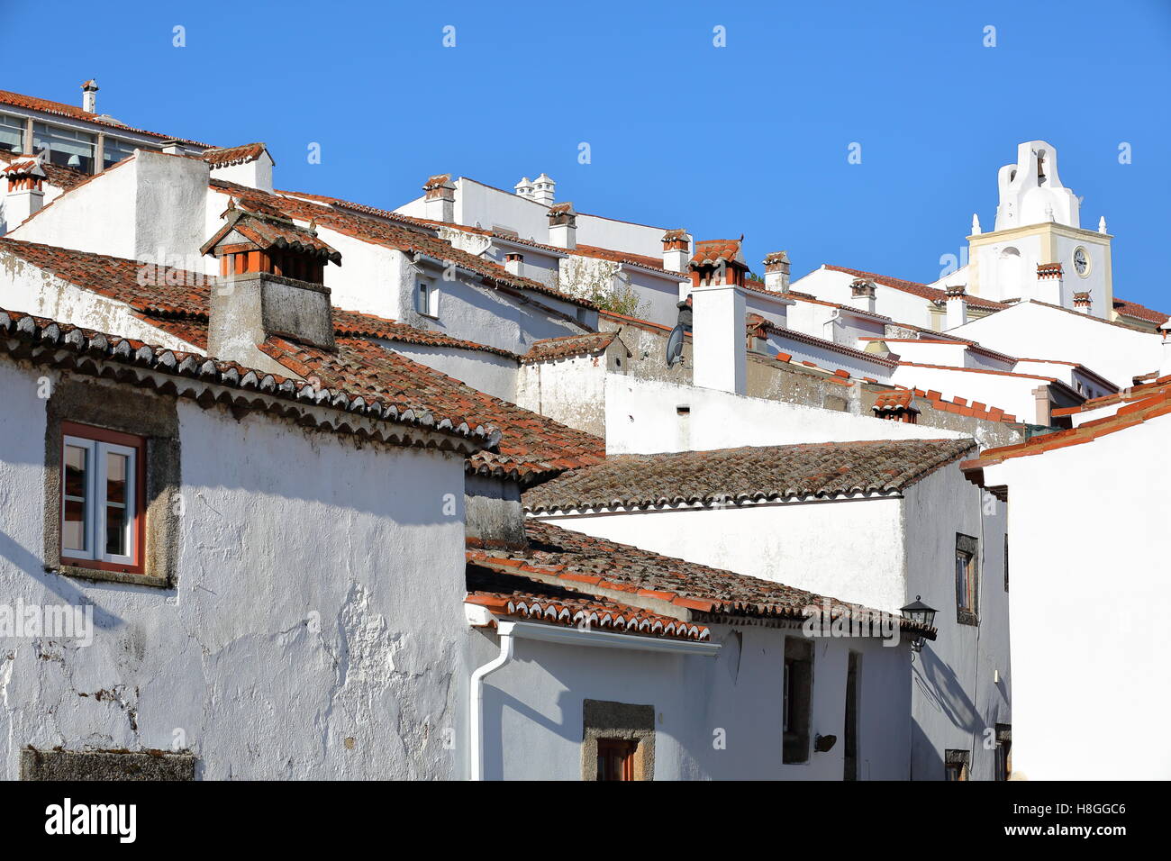 MARVAO, PORTUGAL : une rue pavée typique avec des toits de maisons blanchies à la chaux et avec la tour de l'horloge en arrière-plan Banque D'Images