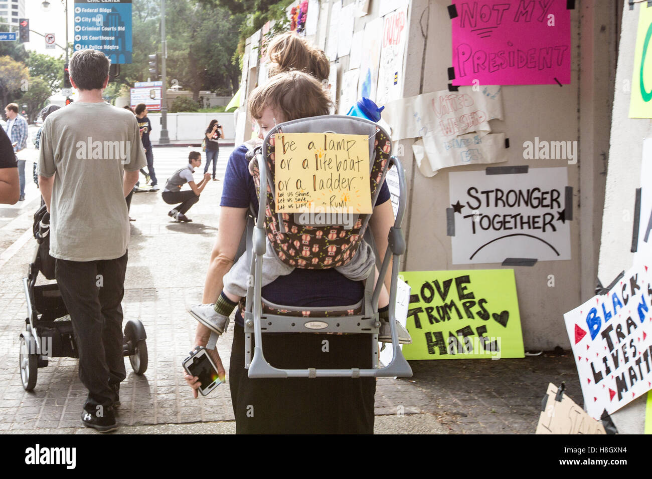 Los Angeles, Californie, USA. 12 novembre, 2016. Une mère porte son enfant avec un signe sur le dos de l'enfant transporteur au lieu mars anti-trump à Los Angeles, Californie. crédit : Sheri determan / alamy live news Banque D'Images