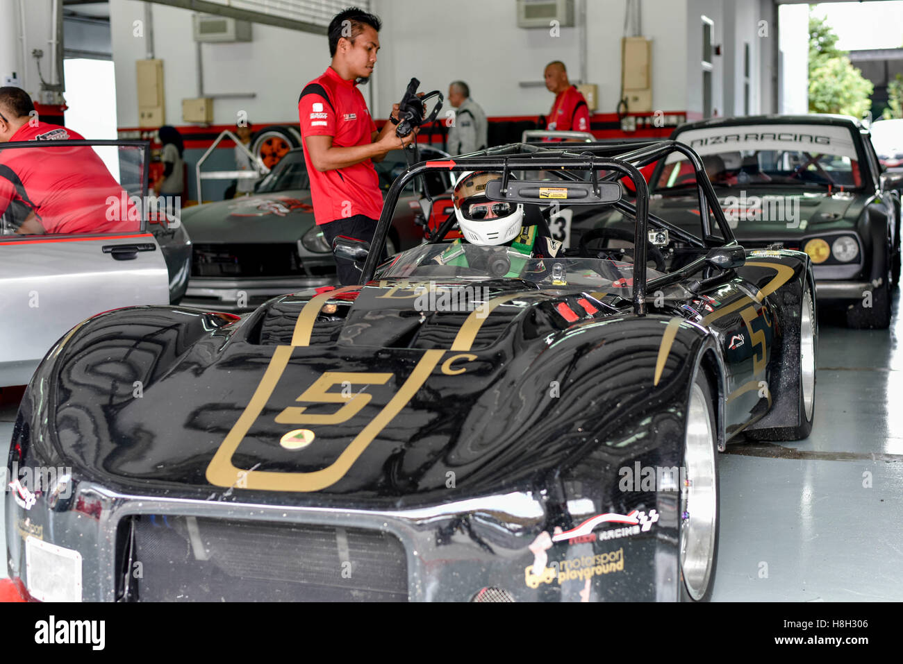 Kelvin Davies de l'équipe membres de l'équipage voiture vérifier l'Sylva Phoenix sur le paddock avant le défi de voitures classiques de l'Asie le 12 novembre 2016 au Circuit International de Sepang à Kuala Lumpur, Malaisie. Banque D'Images