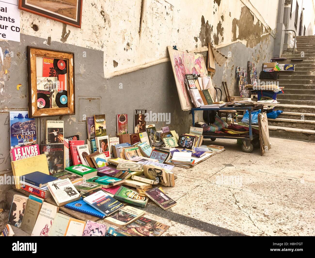 Vendeur de livres d'exposer les livres sur la rue en vieille ville d'Alger centre. Les gens communiquent par 3 langues en Algérie, coiffure langag Banque D'Images