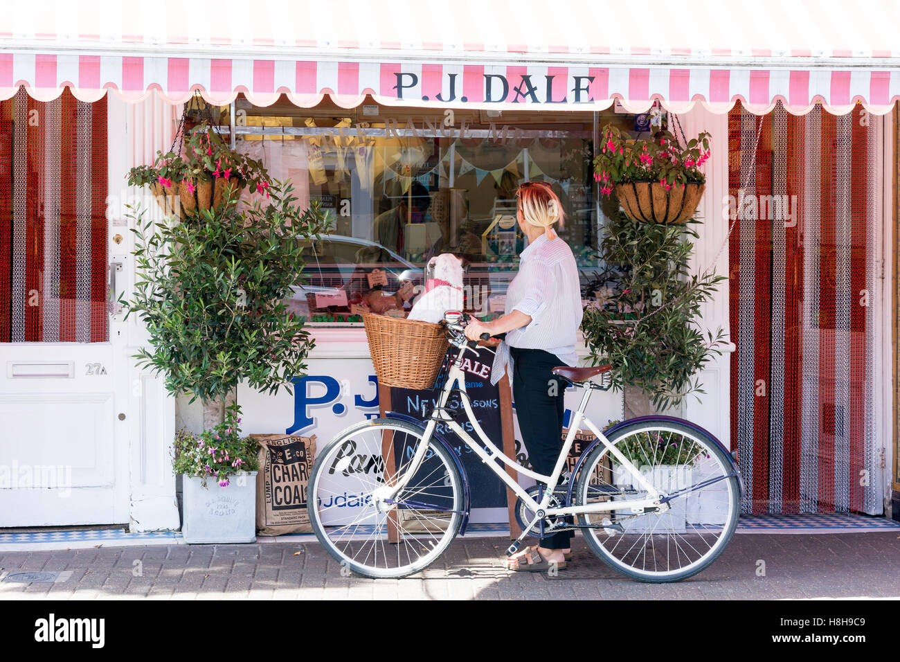 Femme avec location en dehors de P.J.Dale bouchers, Bridge Street, East Molesey, Surrey, Angleterre, Royaume-Uni Banque D'Images