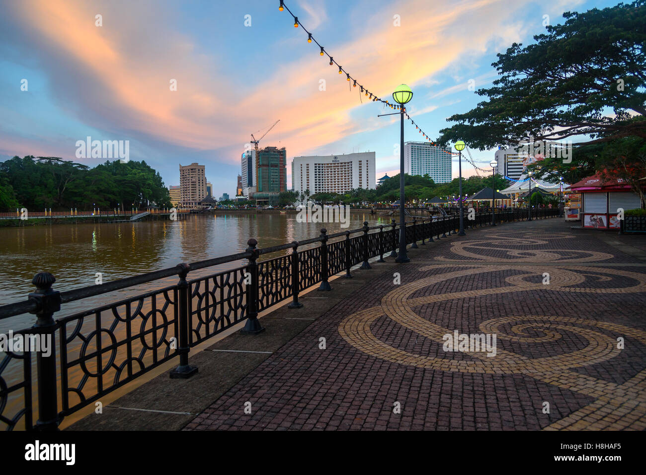 La ville de Kuching waterfront au coucher du soleil. Les gens marchent dans la rue. Sarawak. Malaisie Bornéo Banque D'Images