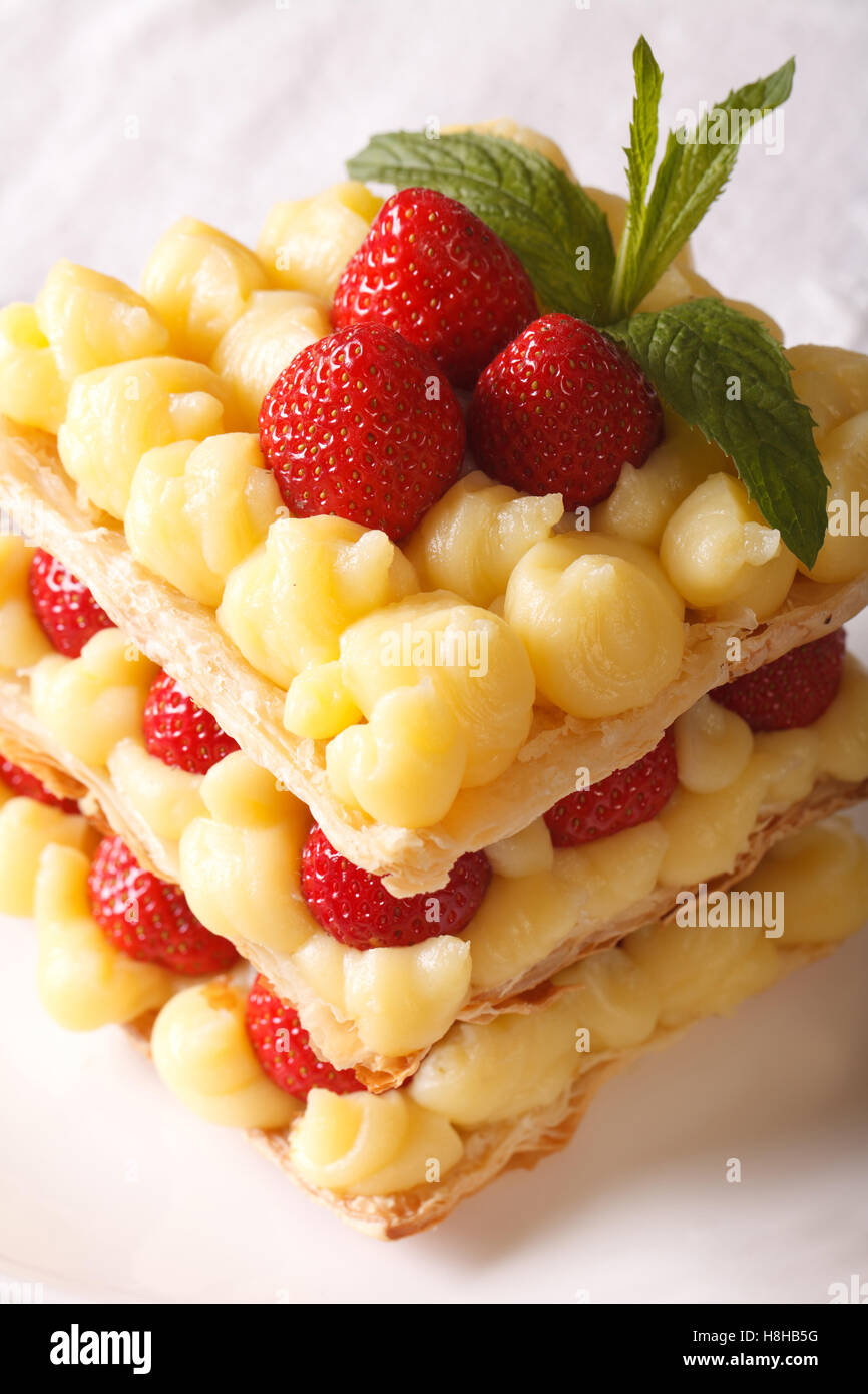 Cuisine française : millefeuille de fraises avec de la crème anglaise, décoré de menthe, close-up vertical. Banque D'Images