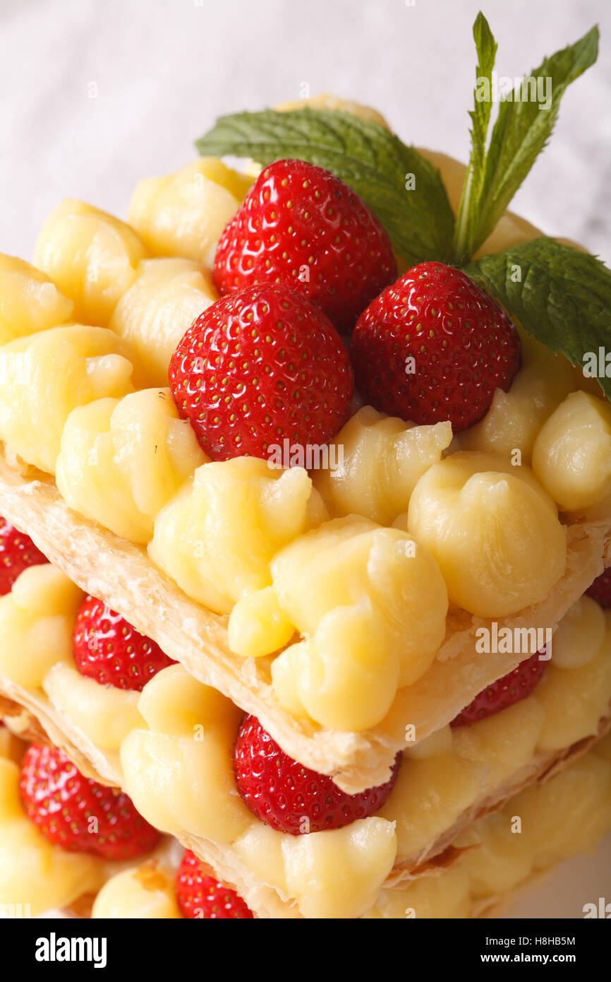 Millefeuille aux fraises savoureuses avec crème, décoré de menthe, close-up vertical. Banque D'Images