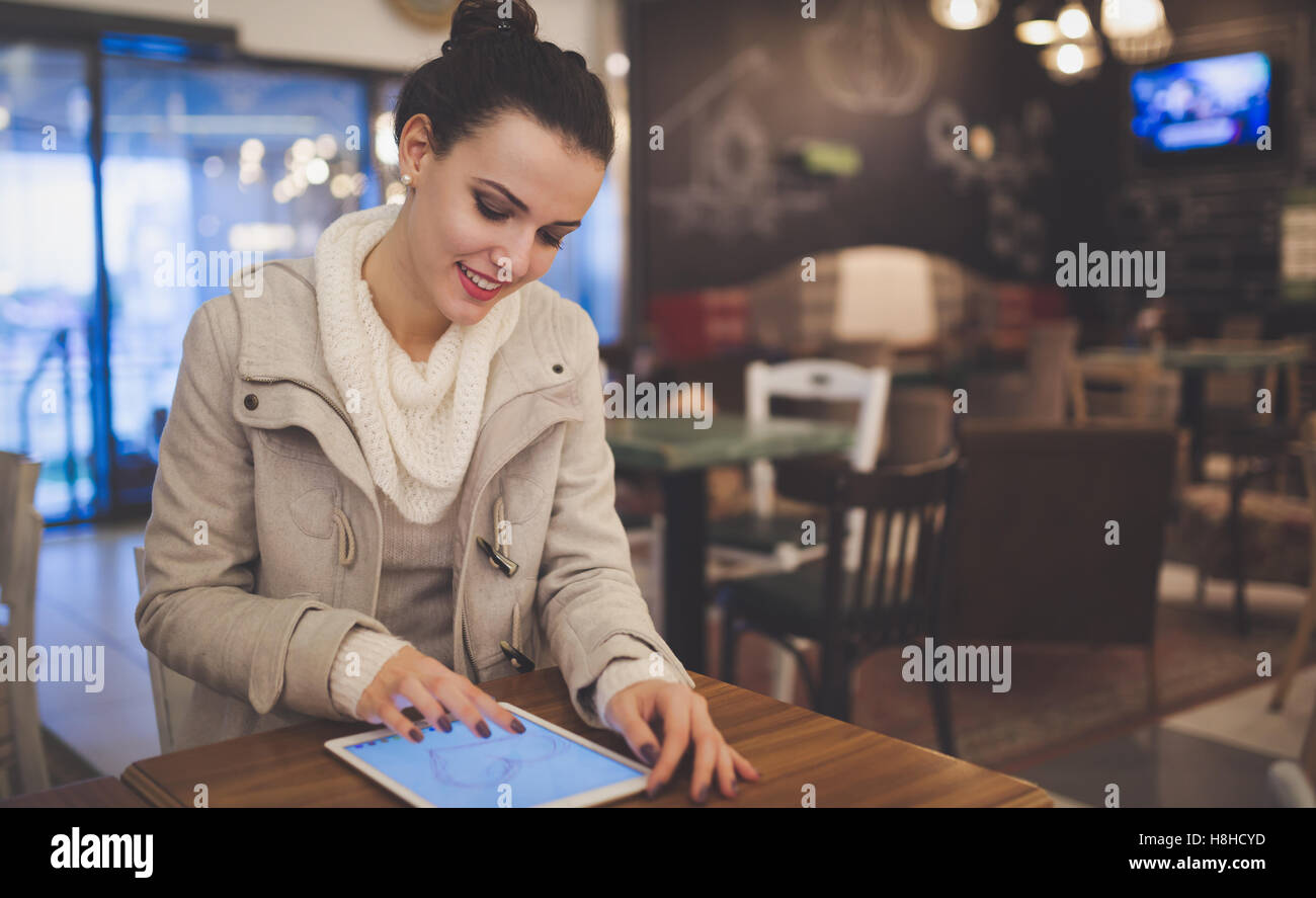 Femme dans l'amour à l'aide de tablet in restaurant Banque D'Images