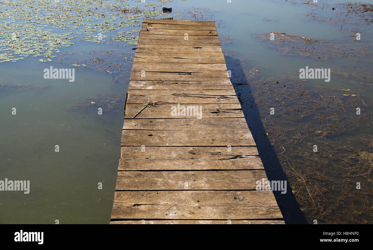 Petit vieux lac pier fabriqué à partir de bois sur la surface de l'eau tôt le matin sur Banque D'Images
