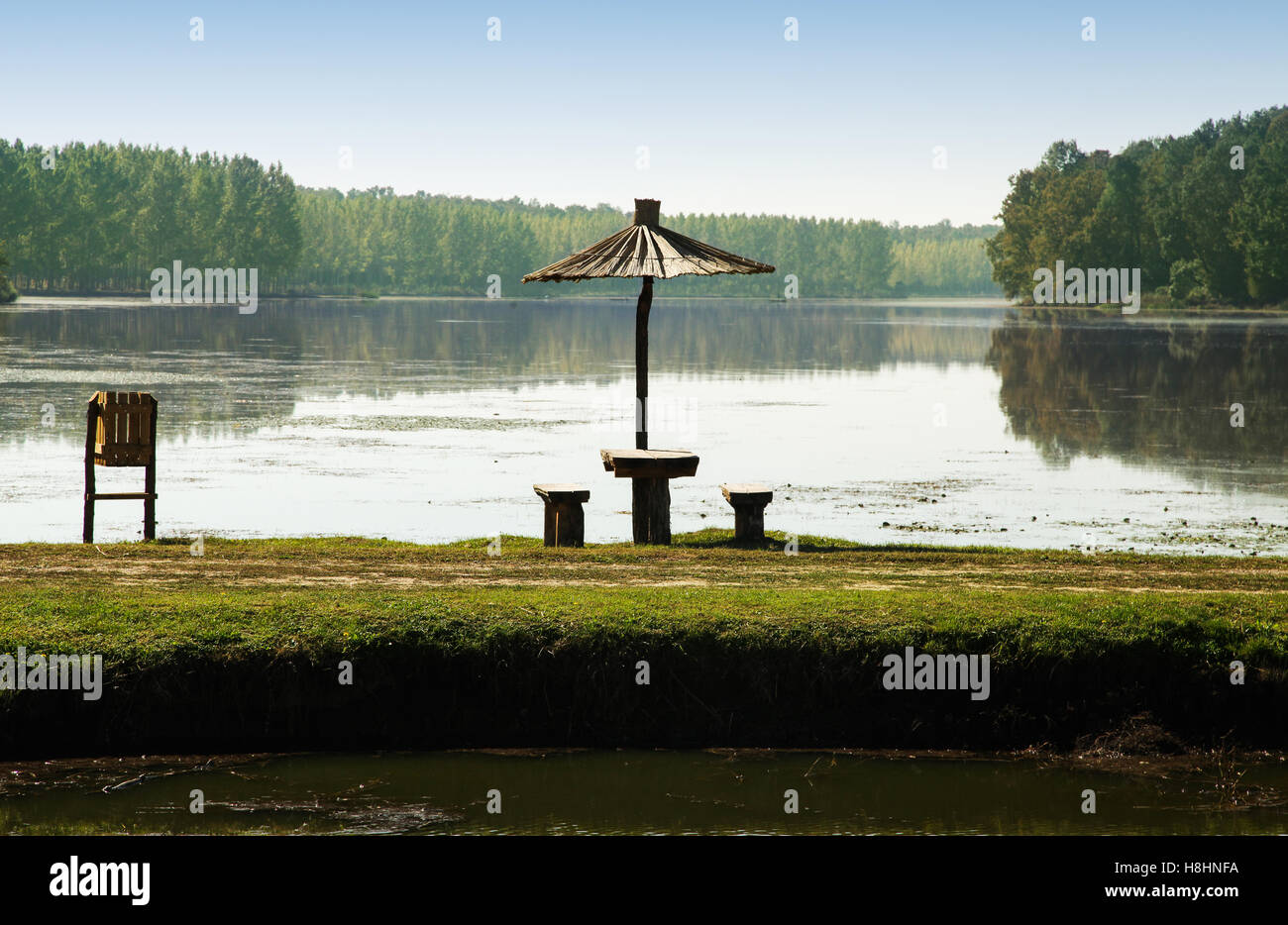 Lac avec un bel endroit de vacances avec des bancs en bois et de shader de canne Banque D'Images