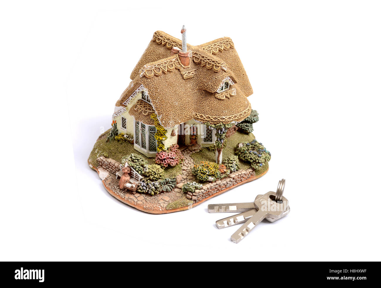 Maison miniature avec une touche sur fond blanc. Banque D'Images