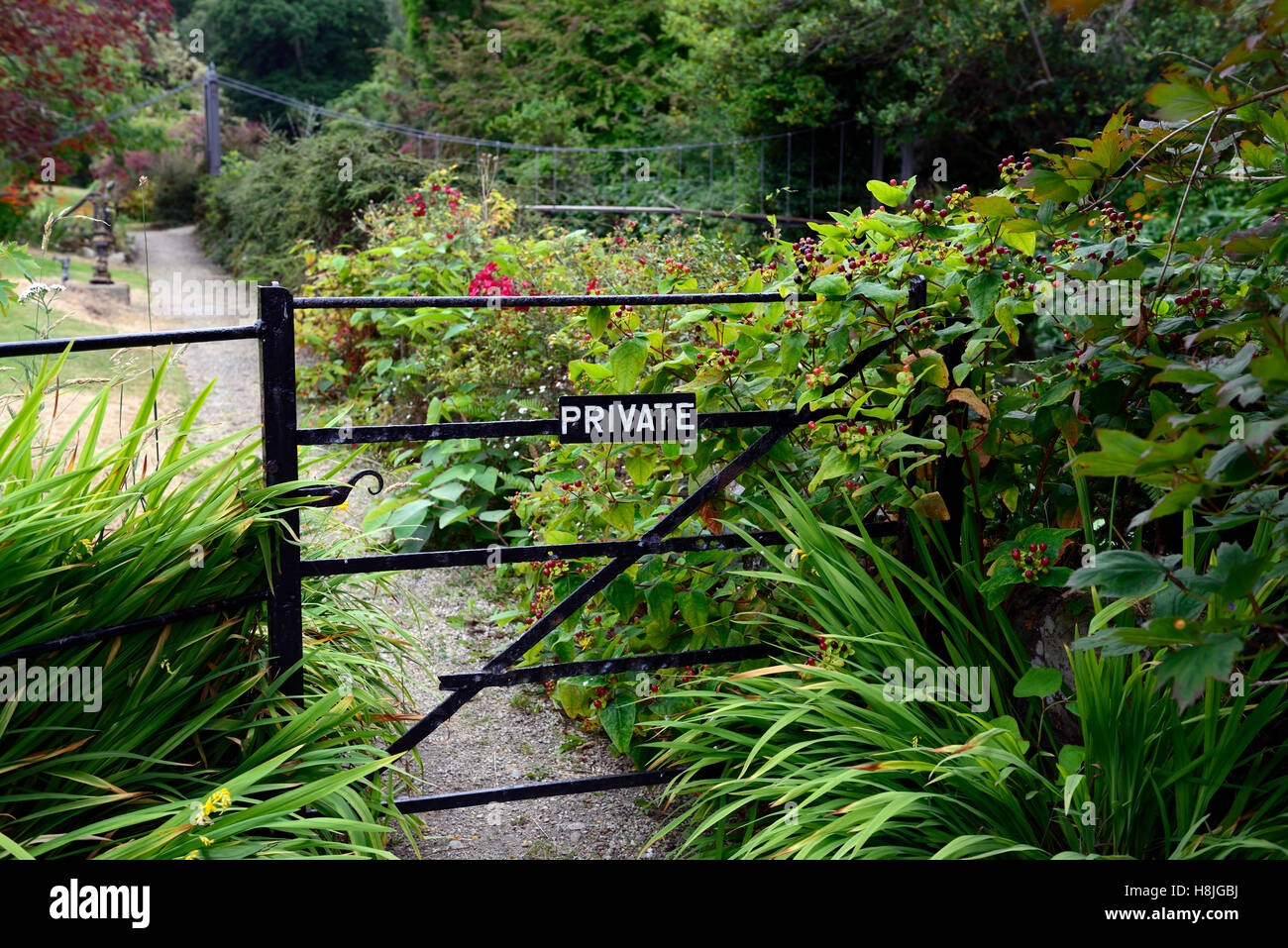 Portail fermé fermé panneau privé entrée chemin de jardin lit mélangé mix vivaces frontière hors des limites de l'article jardins de mount usher Banque D'Images