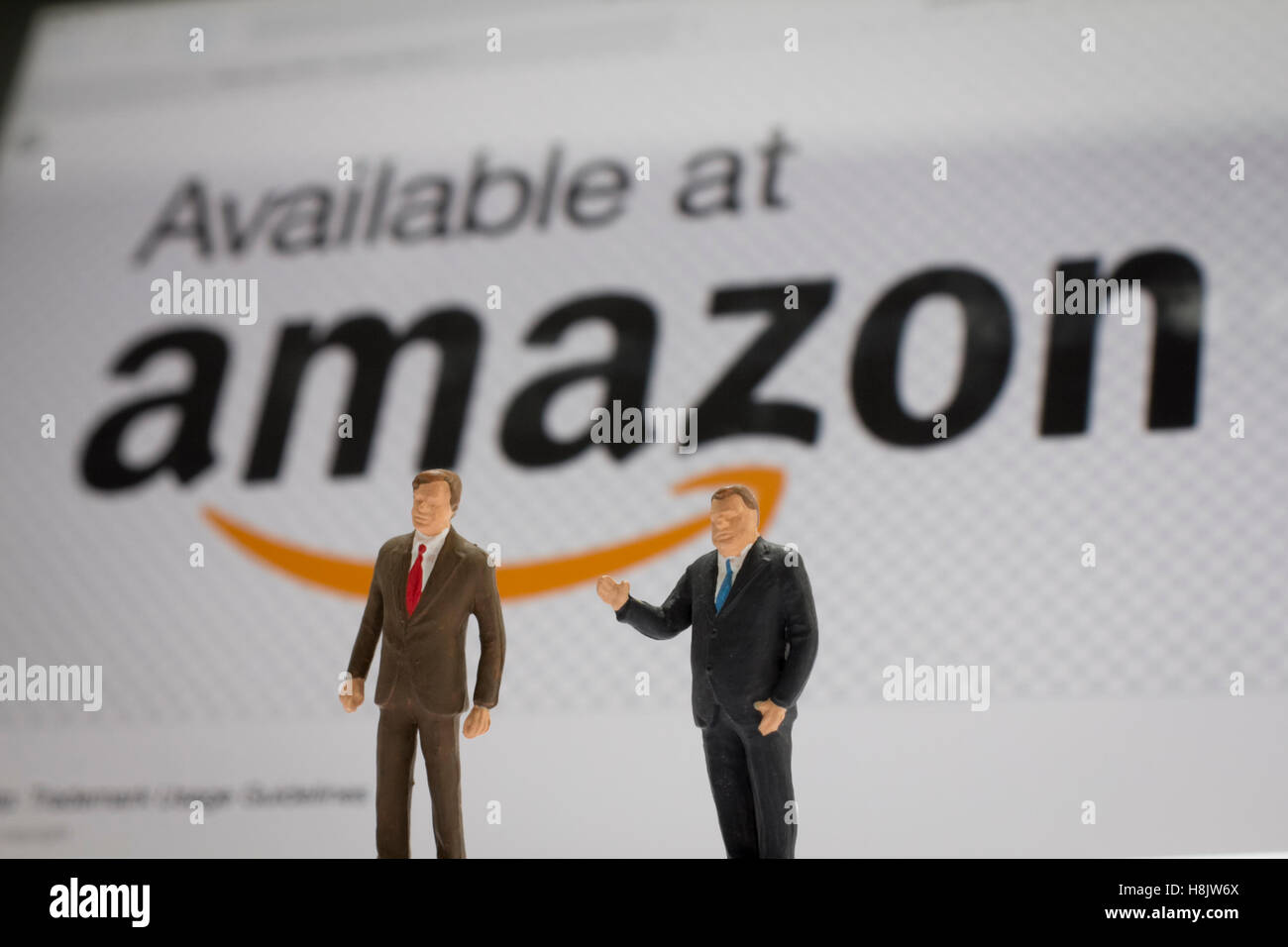 Les maquettes des gens d'affaires posés en face de amazon logo, le site web d'achats Banque D'Images