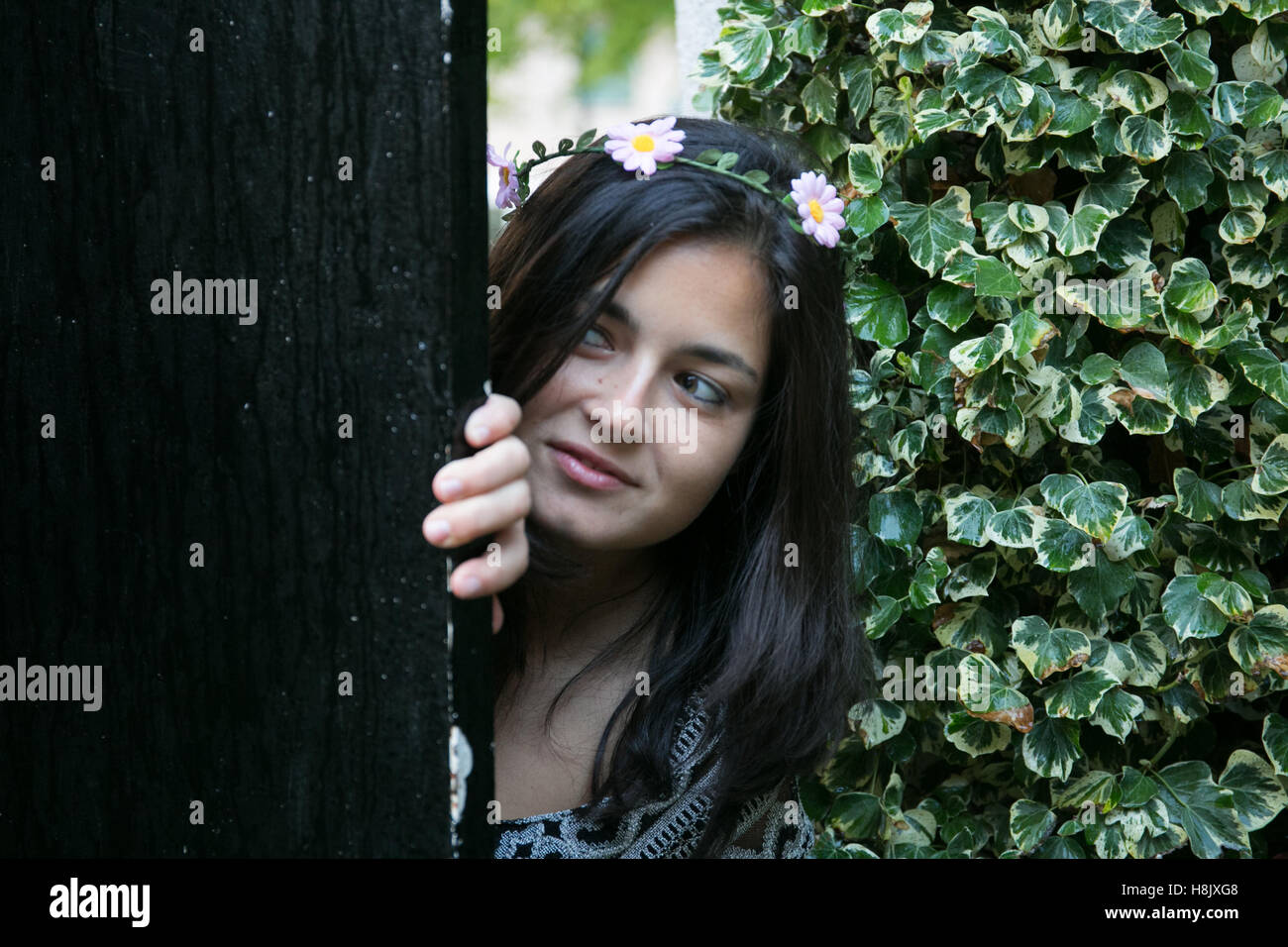 Jeune fille à la porte d'un jardin. Banque D'Images