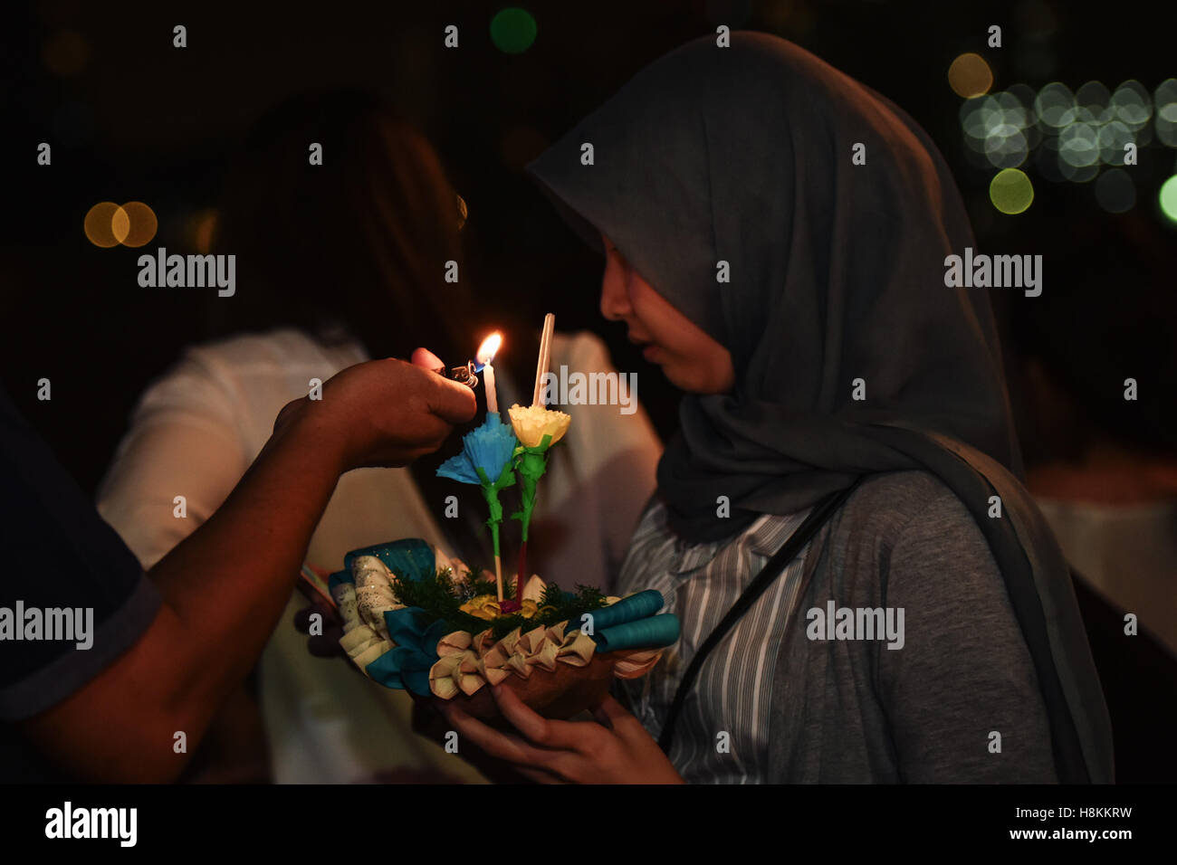 Bangkok, Thaïlande. 14Th Nov, 2016. Un couple s'allumer un Krathong avant de le mettre à flot le long de la Chao Phraya à Bangkok, capitale de la Thaïlande, le 14 novembre 2016. La Thaïlande a observé le Loy Krathong festival annuel le lundi. Comme une tradition qui a été suivie pendant au moins sept siècles, les gens mis à flot des radeaux en forme de lotus ornée de bougies, encens et fleurs, connu comme Les Krathongs illumines, autour de la Douzième Nuit de pleine lune du calendrier thaïlandais tout en souhaitant une année de mauvaise chance d'être emportées par les eaux. © Li Mangmang/Xinhua/Alamy Live News Banque D'Images
