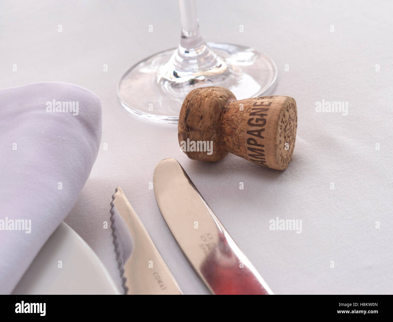Table à manger de luxe en LIÈGE au champagne avec réflexion au champagne et liège de champagne rosé vintage sur la nappe Banque D'Images