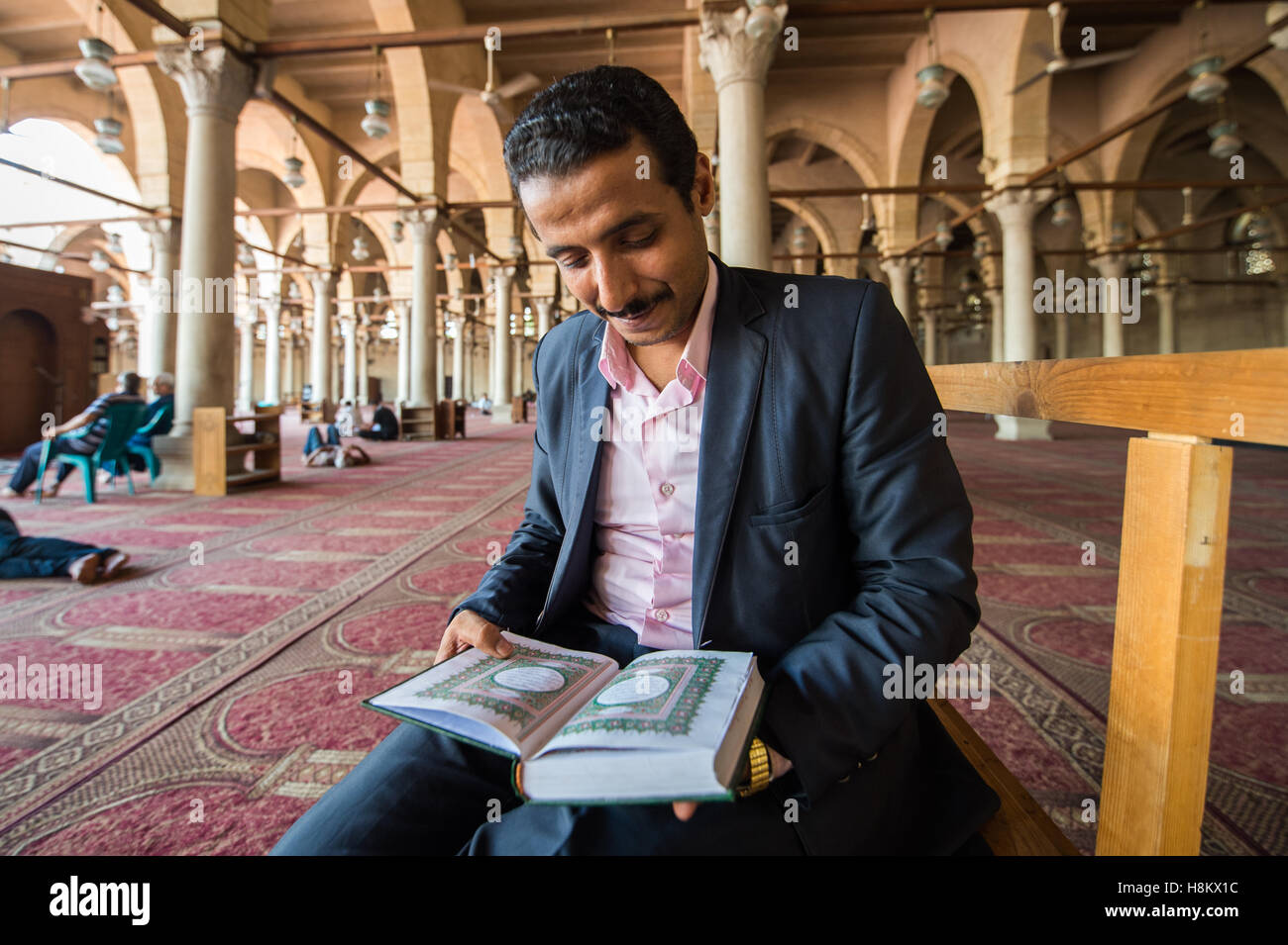 Le Caire, Égypte. L'homme égyptien lecture du Coran à l'intérieur d'une mosquée au Caire. Banque D'Images