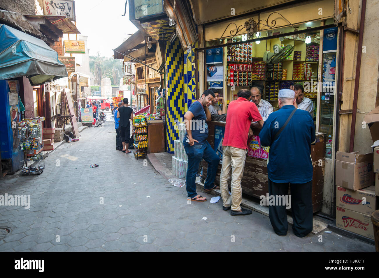 Le Caire, Égypte. Les gens marcher dans les magasins et s'adressant à des propriétaires de magasins le long d'une ruelle dans le marché aux puces en plein air/ bazar Khan Banque D'Images