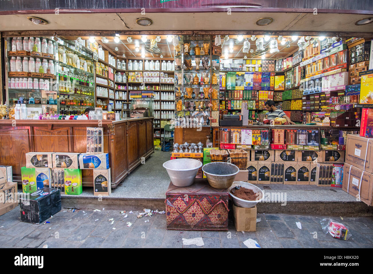 Le Caire, Égypte. Caisse debout derrière le registre d'un magasin de vente d'une gamme d'encens et d'autres marchandises dans le bazar en plein air/ Banque D'Images