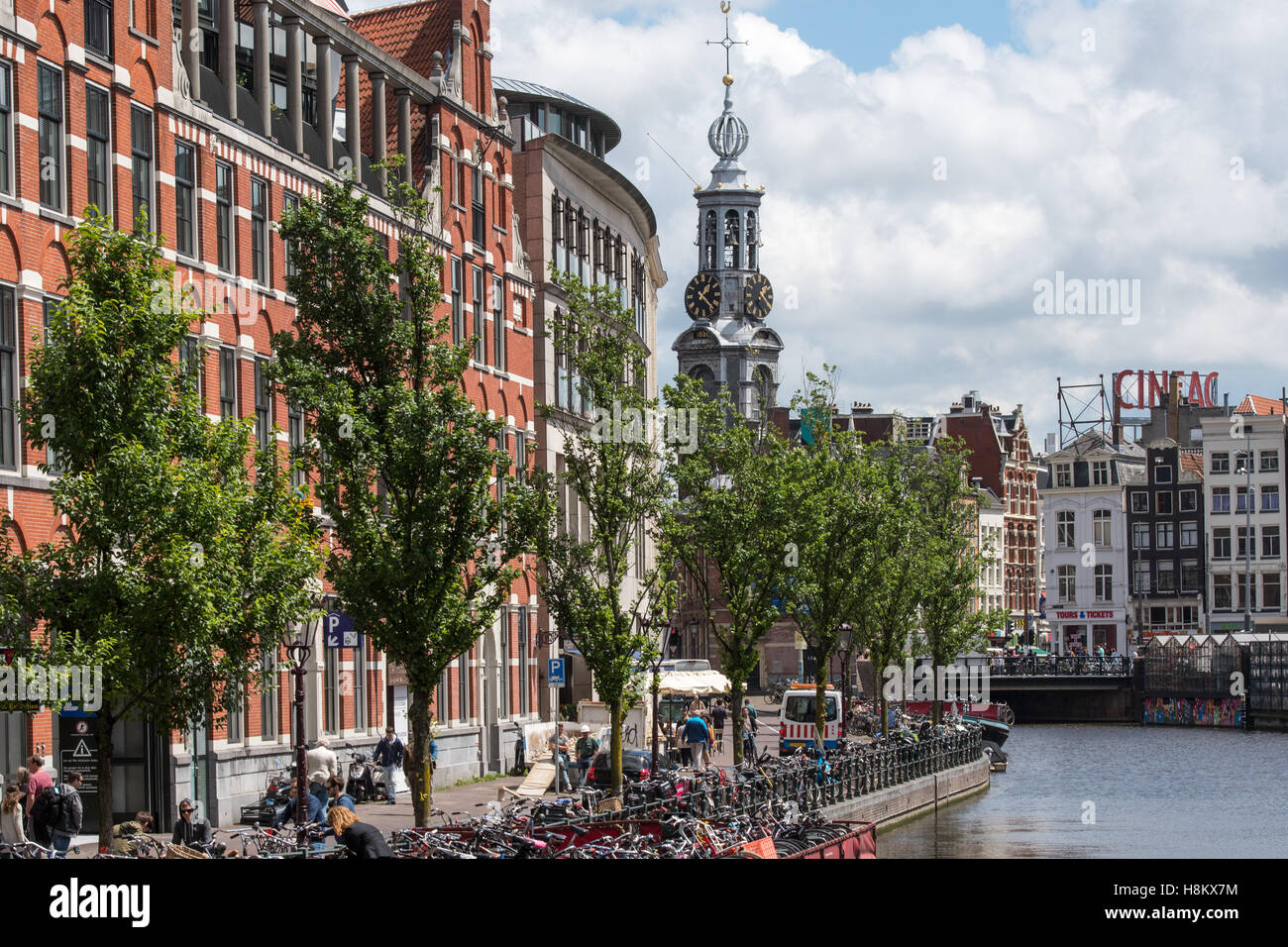 Amsterdam, Pays-Bas vue front de touristes marcher le long d'un canal à Amsterdam. Dans l'arrière-plan est la tour avec Banque D'Images