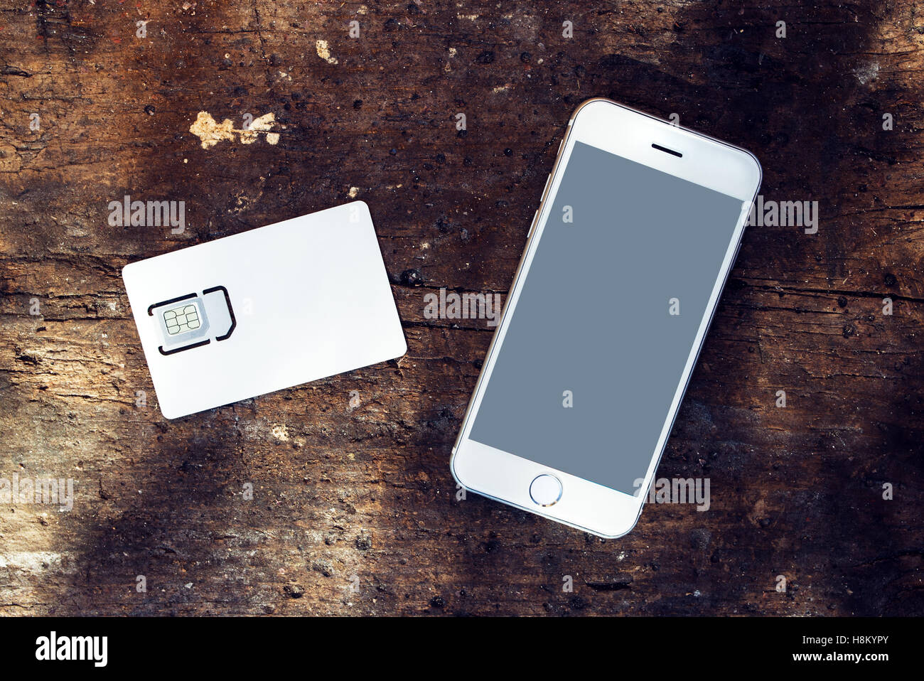 Smartphone avec écran blanc et le téléphone mobile CARTE SIM GSM sur la table, vue du dessus Banque D'Images