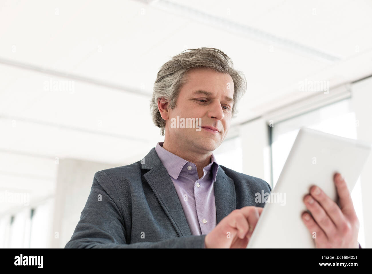 Mature businessman using tablet computer in nouveau bureau Banque D'Images