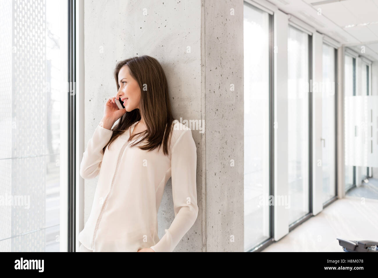 Young businesswoman using digital tablet sur mur dans nouveau bureau Banque D'Images