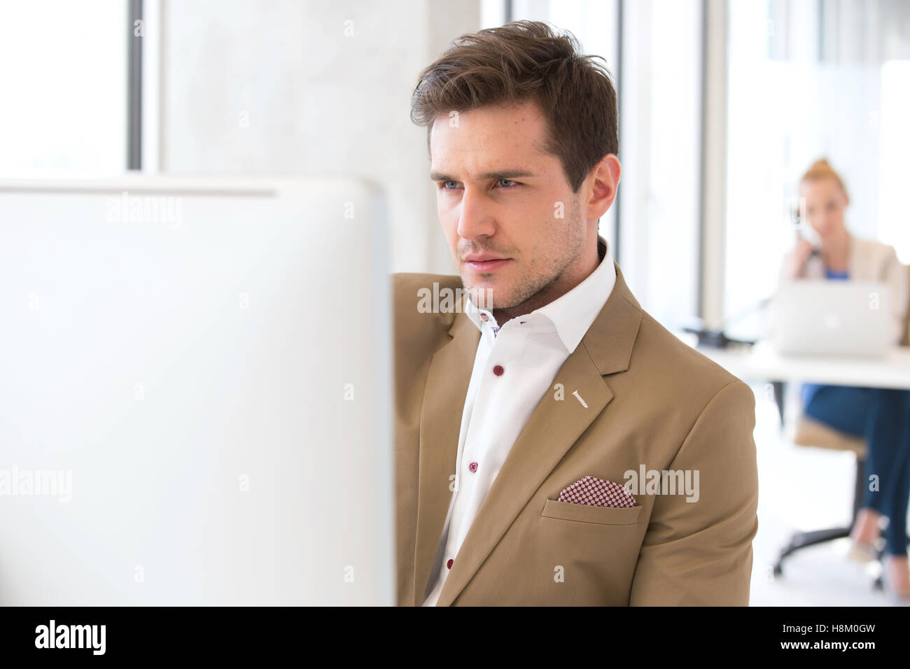 Handsome young businessman using computer in office Banque D'Images