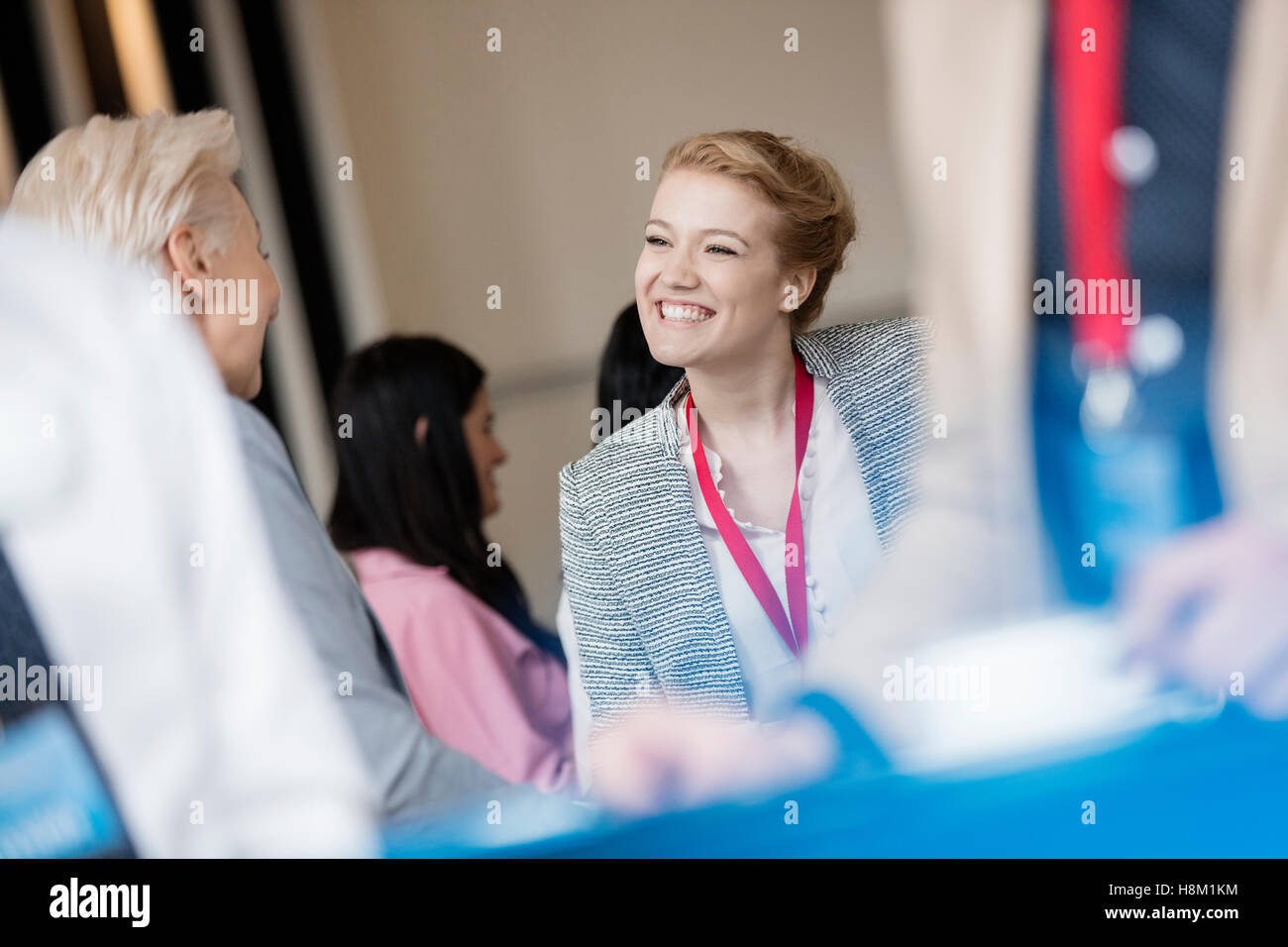 Happy businesswoman talking to colleague at lobby dans convention center Banque D'Images