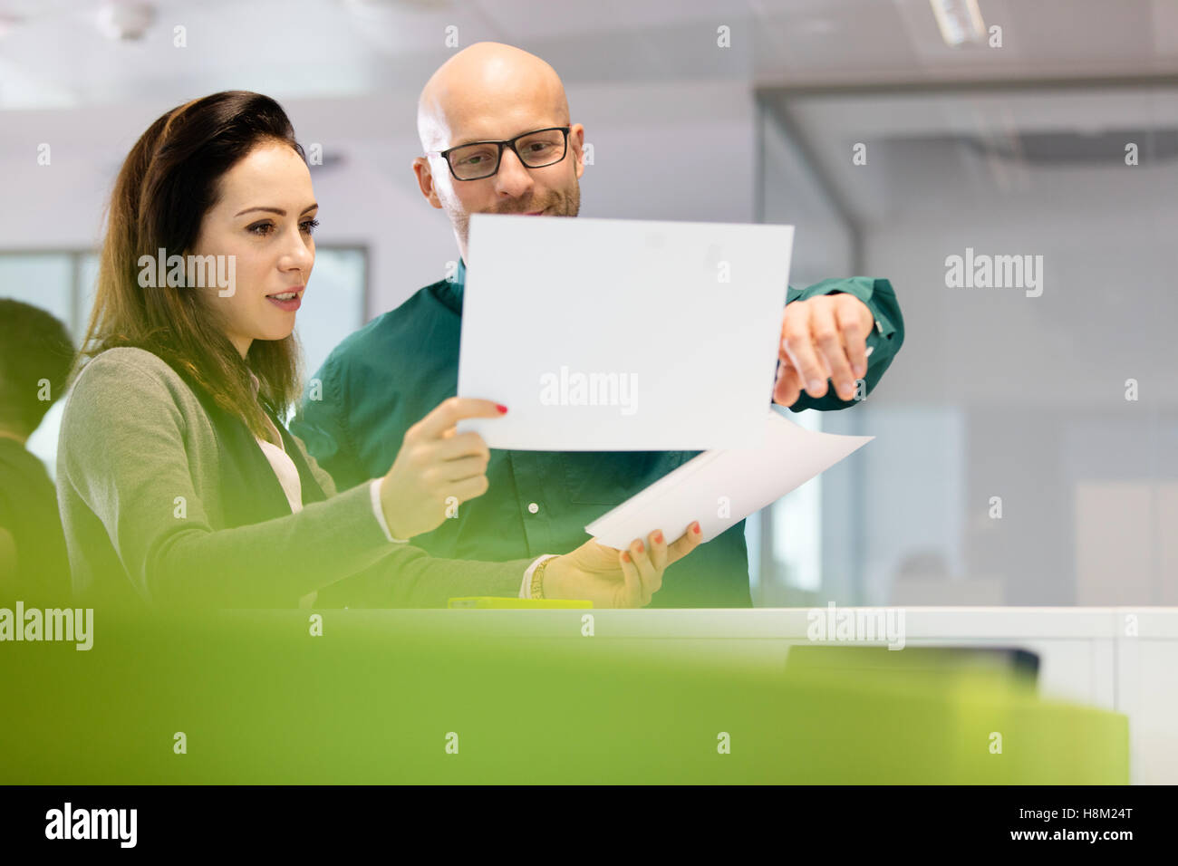 Businesswoman with male colleague discussing over in office Banque D'Images