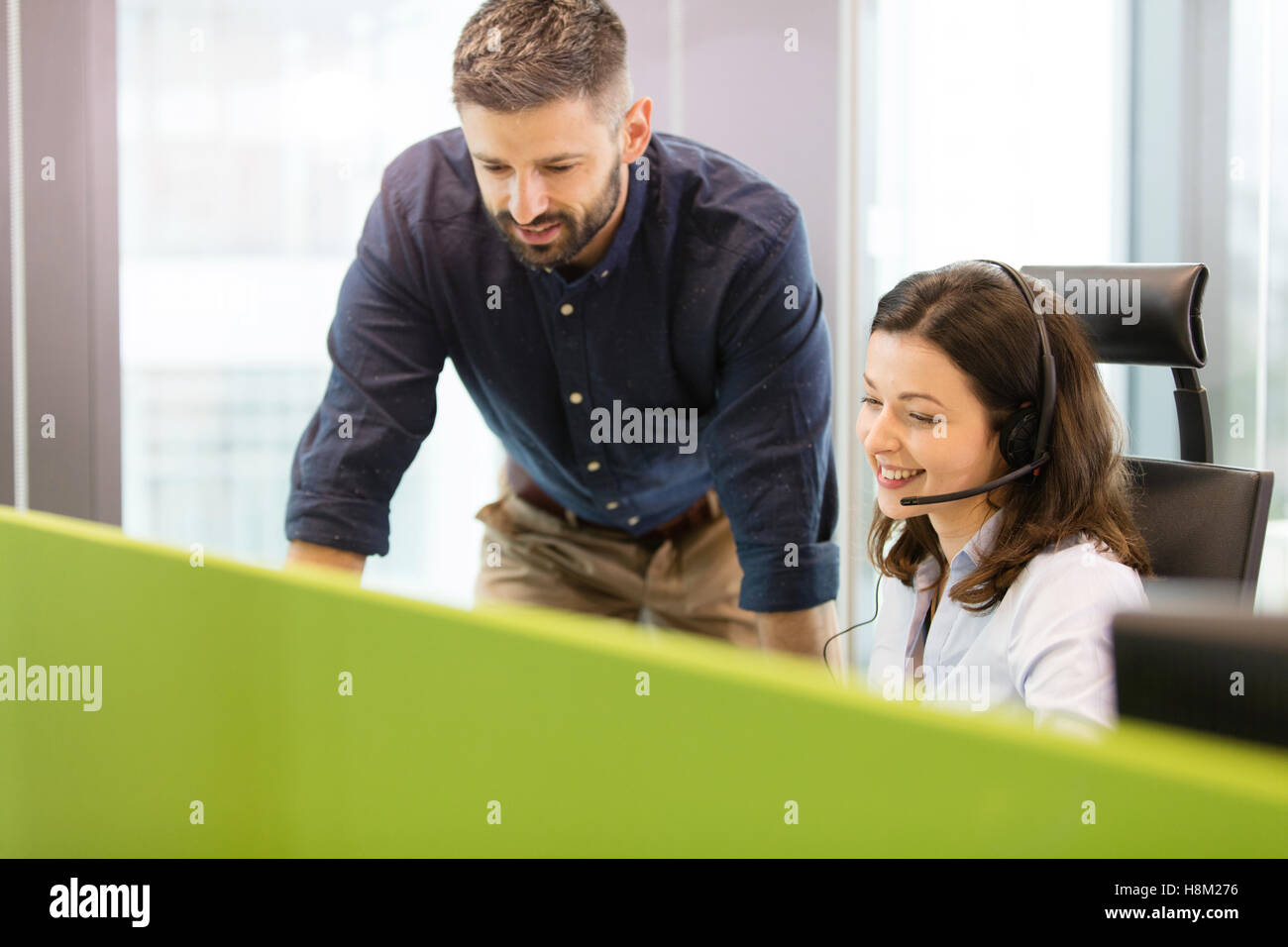 Smiling young woman par collègue masculin in office Banque D'Images