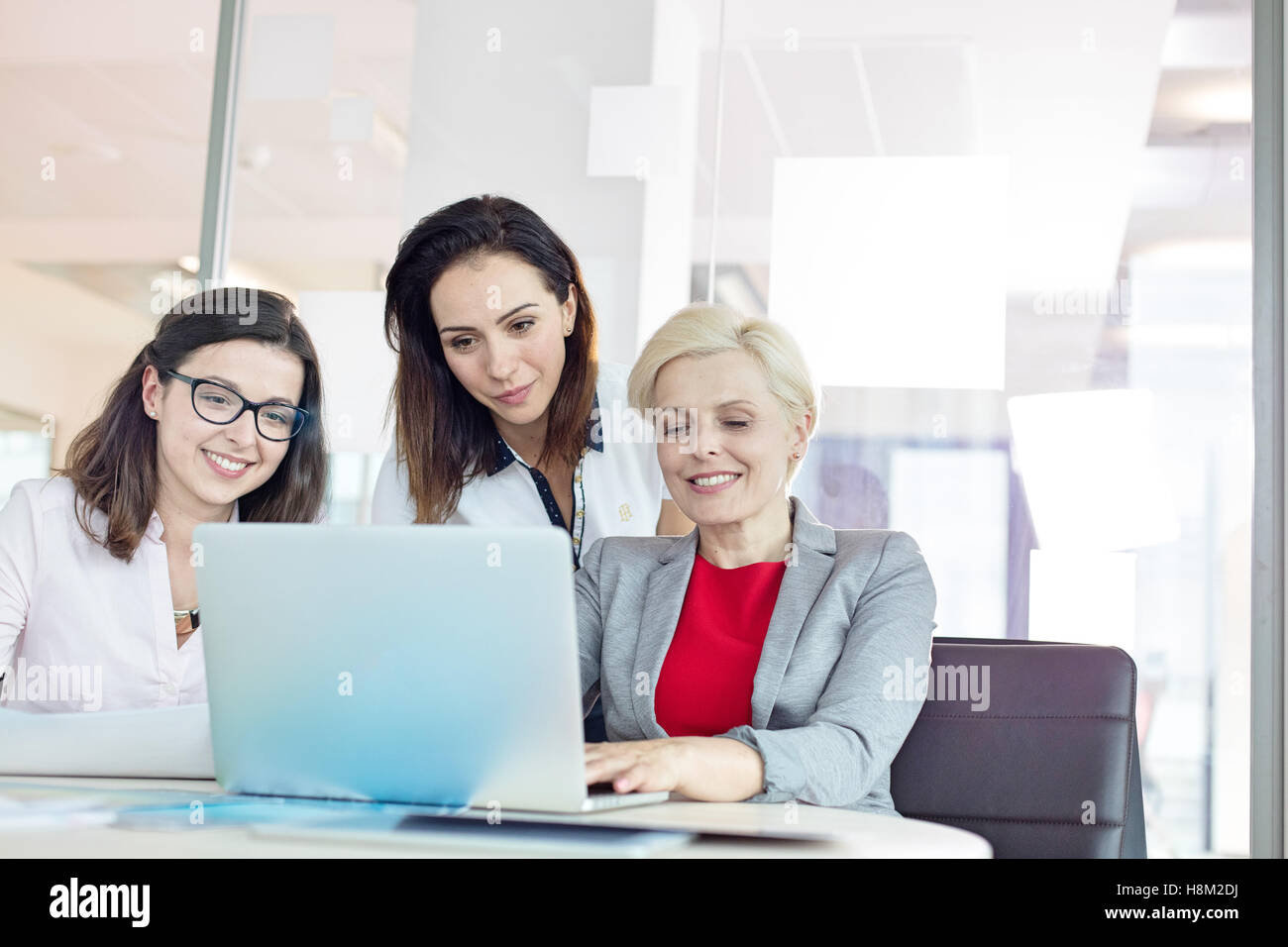 Businesswomen using laptop at table in office Banque D'Images