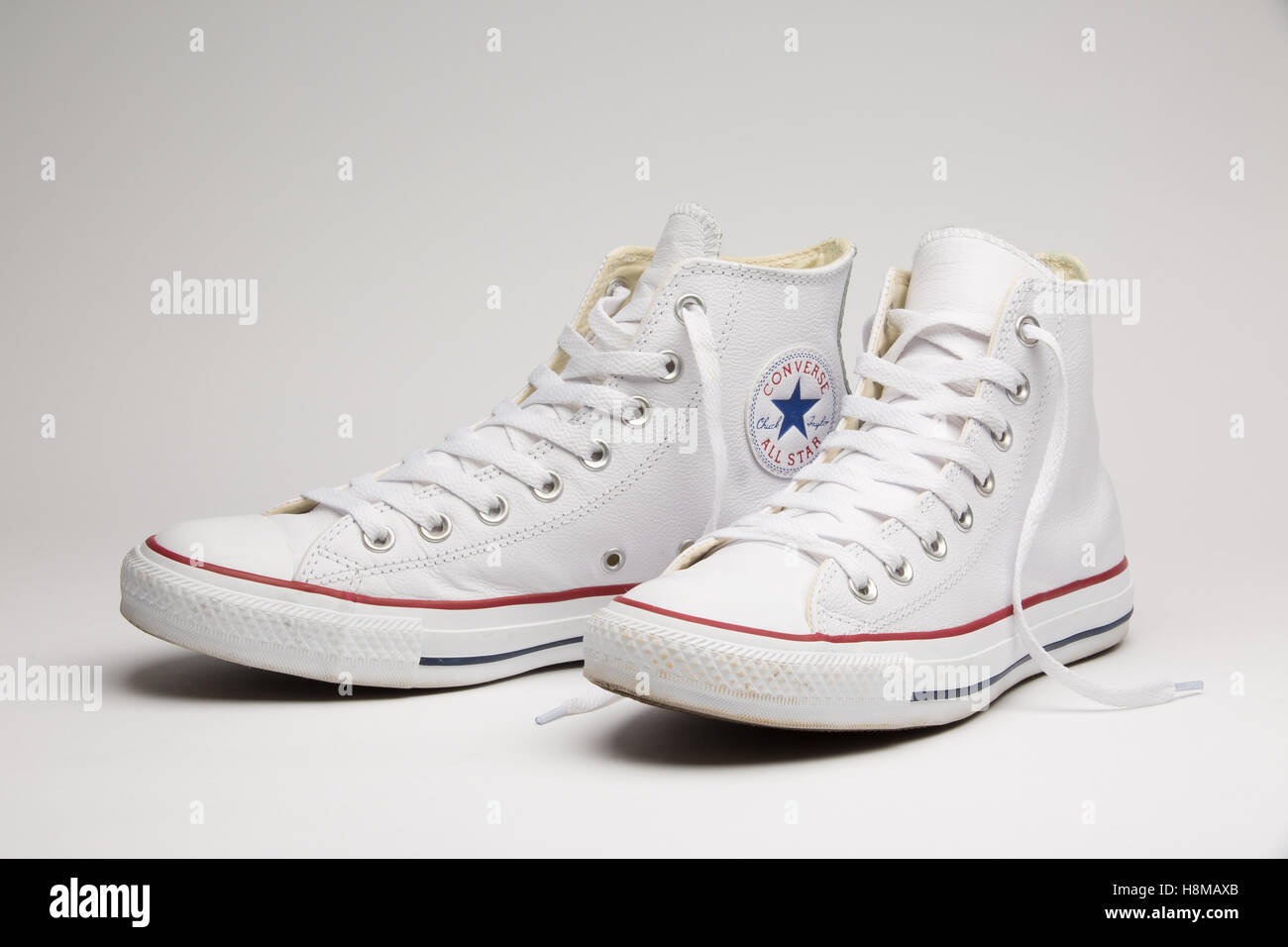 Une paire de baskets Converse blanche, la hauteur de la cheville,  photographié sur un fond uni Photo Stock - Alamy