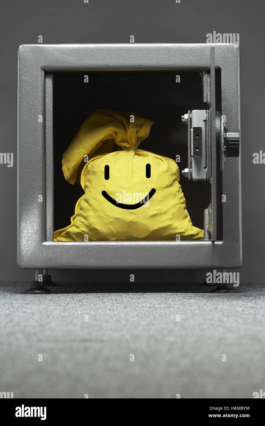 Coffre-fort avec sac jaune avec un visage heureux sur elle Banque D'Images