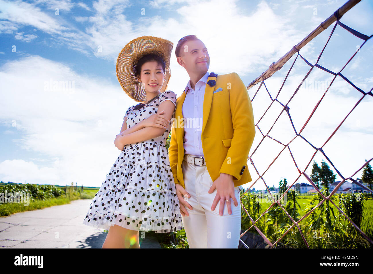 Portrait of smiling woman standing avec l'homme sur terrain against sky Banque D'Images