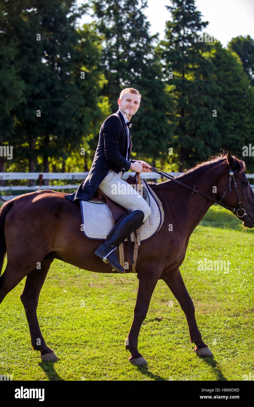 Side view portrait of man riding horse sur terrain Banque D'Images