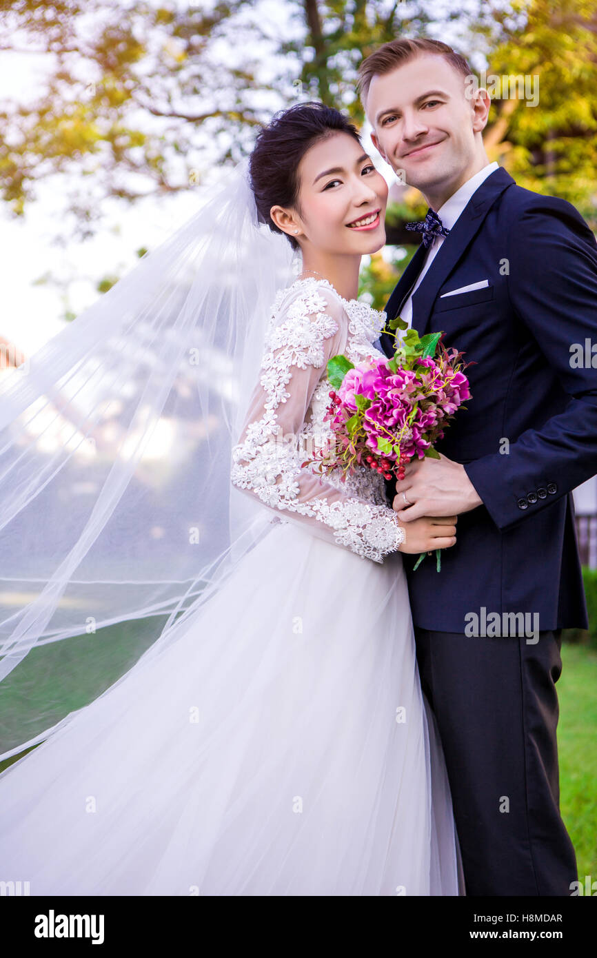 Portrait of happy wedding couple standing at lawn Banque D'Images