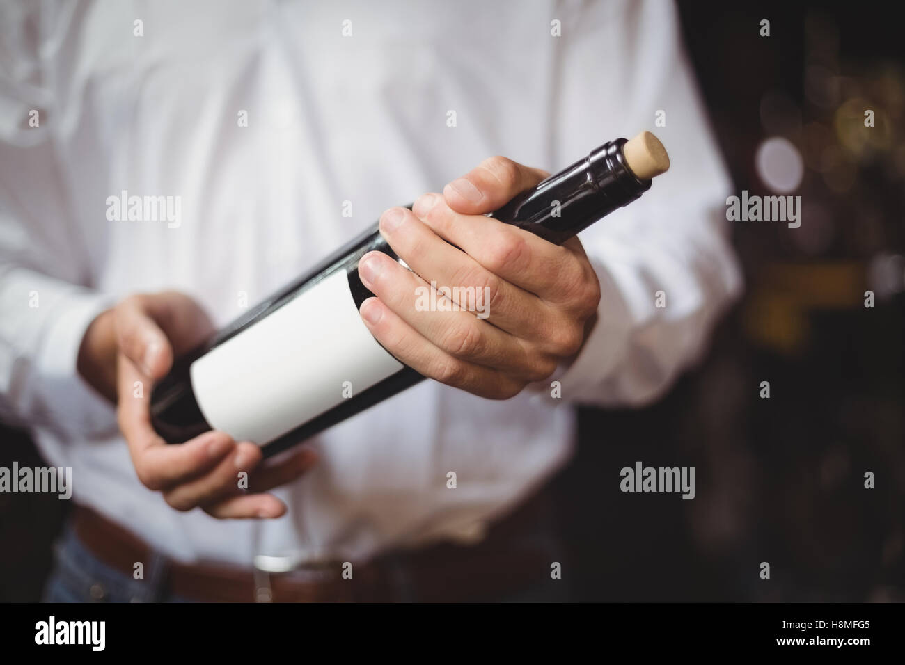 Section intermédiaire de bar offres tenant une bouteille de vin Banque D'Images