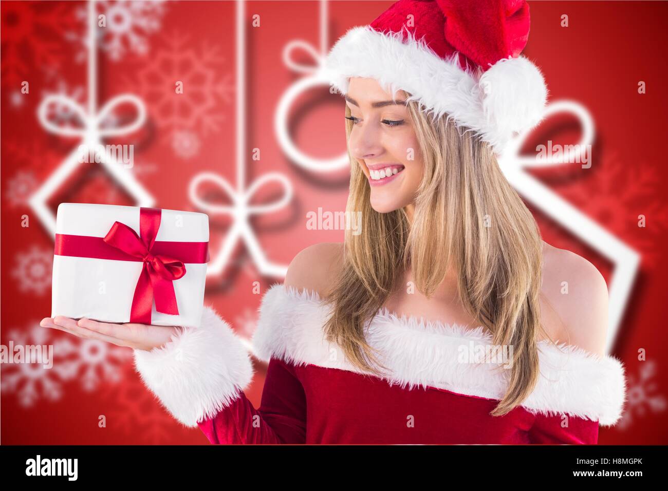 Belle femme en costume santa holding a gift Banque D'Images