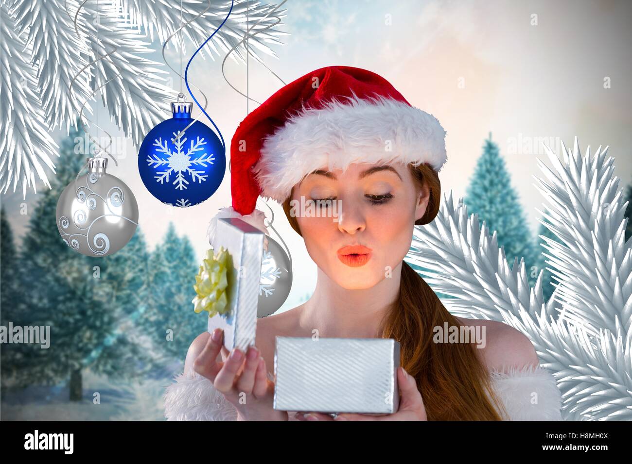 Woman in santa hat looking at Christmas Gift Banque D'Images