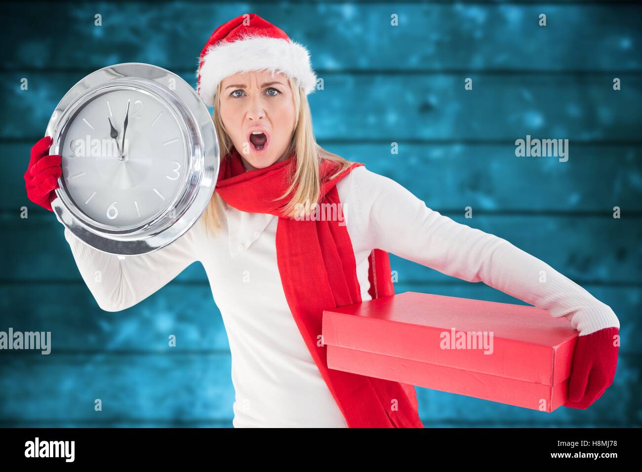 Impatient woman in santa hat holding une horloge et cadeau de Noël Banque D'Images